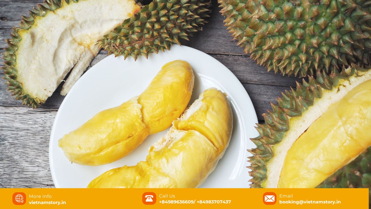 Durian fruit with thorny exterior, cut open to show creamy yellow flesh segments.